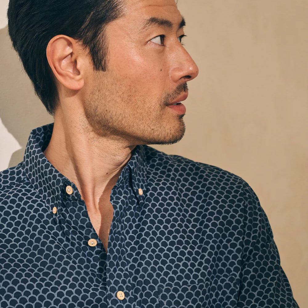 
                      
                        Closeup front view of a man wearing a fishscale print short sleeve button up shirt by Faherty
                      
                    