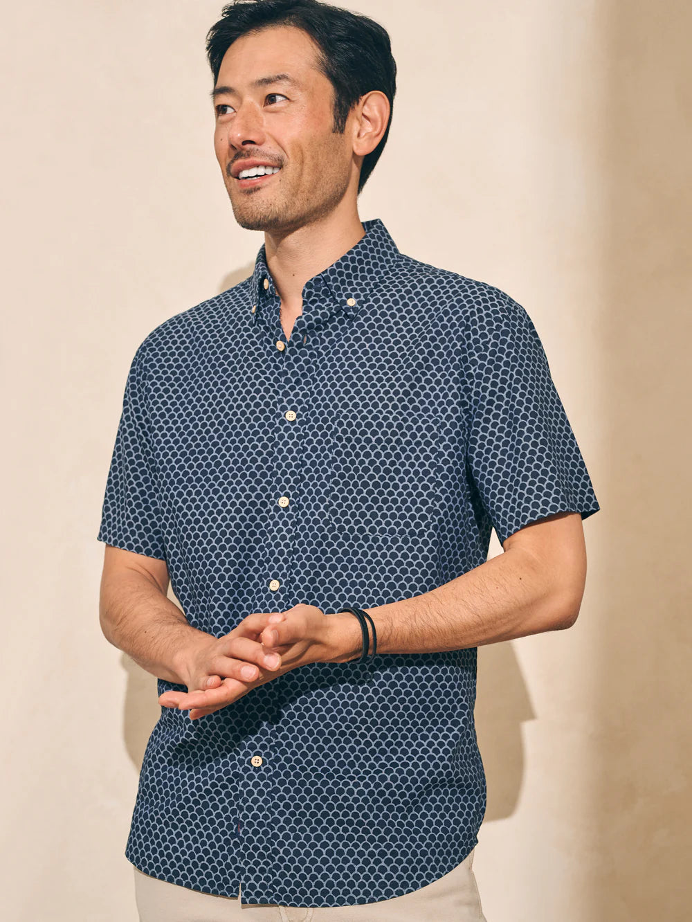 Front view of a man wearing a fishscale print short sleeve button up shirt by Faherty