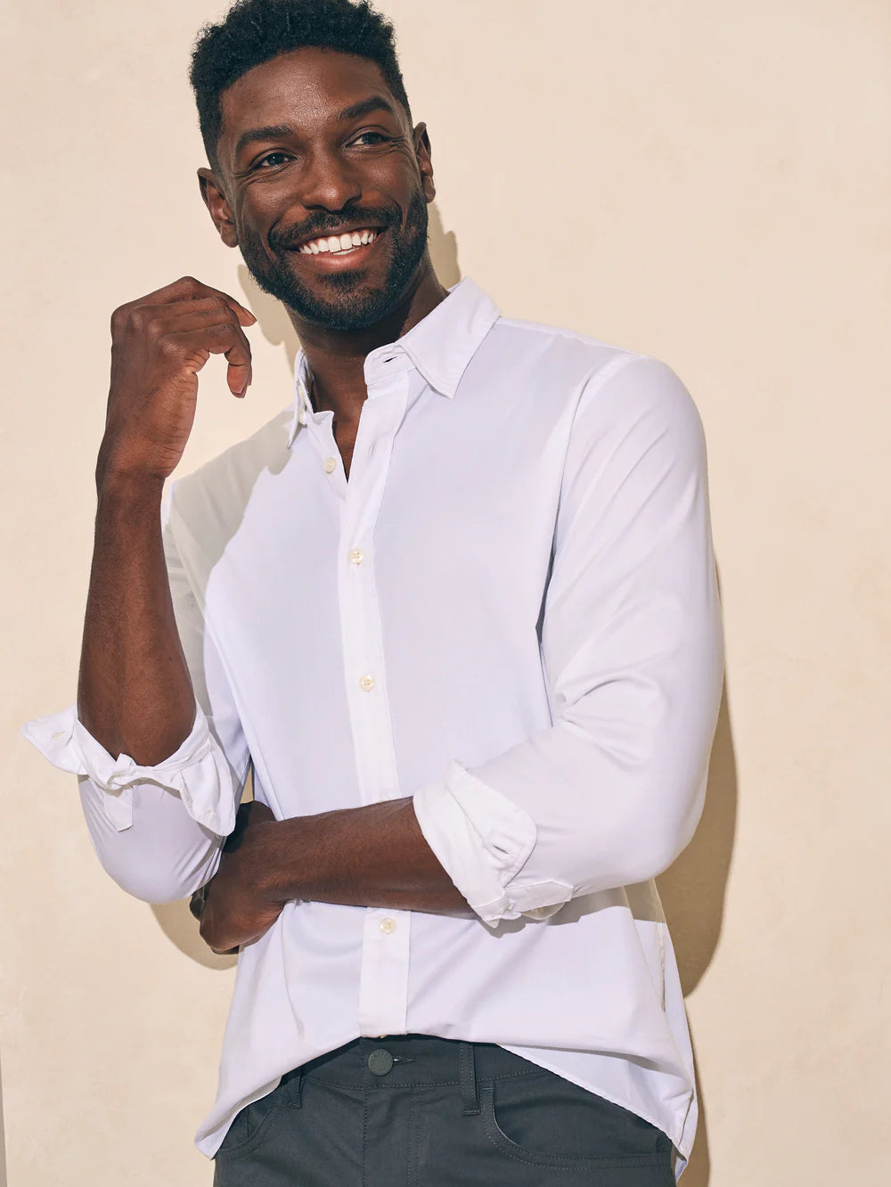 Front view of a man wearing the white long sleeve button up Movement shirt by Faherty