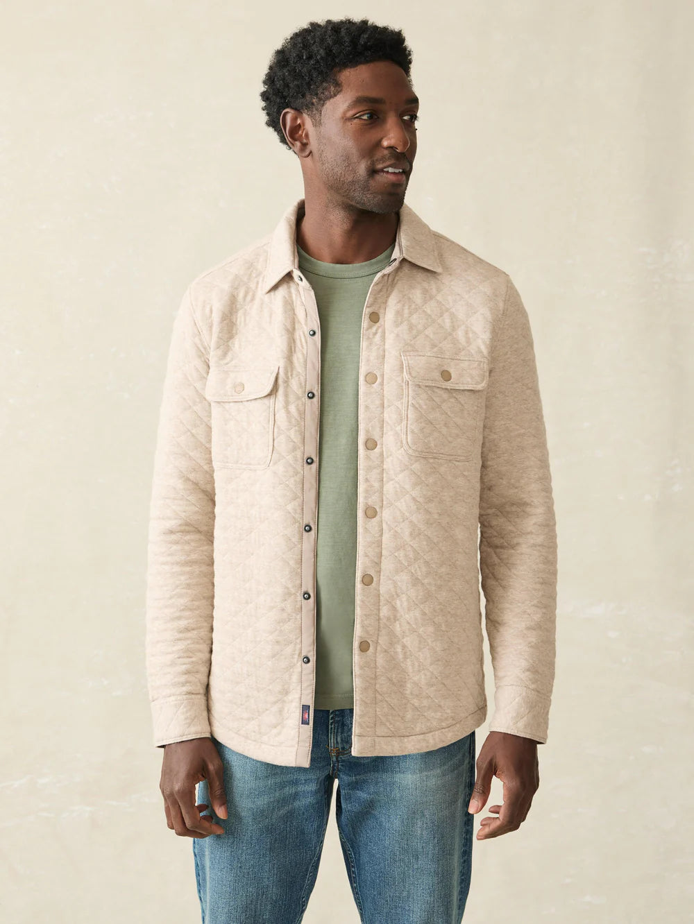 A man wearing the Oatmeal Melange  Epic Quilted Fleece CPO  by Faherty layered over a t-shirt