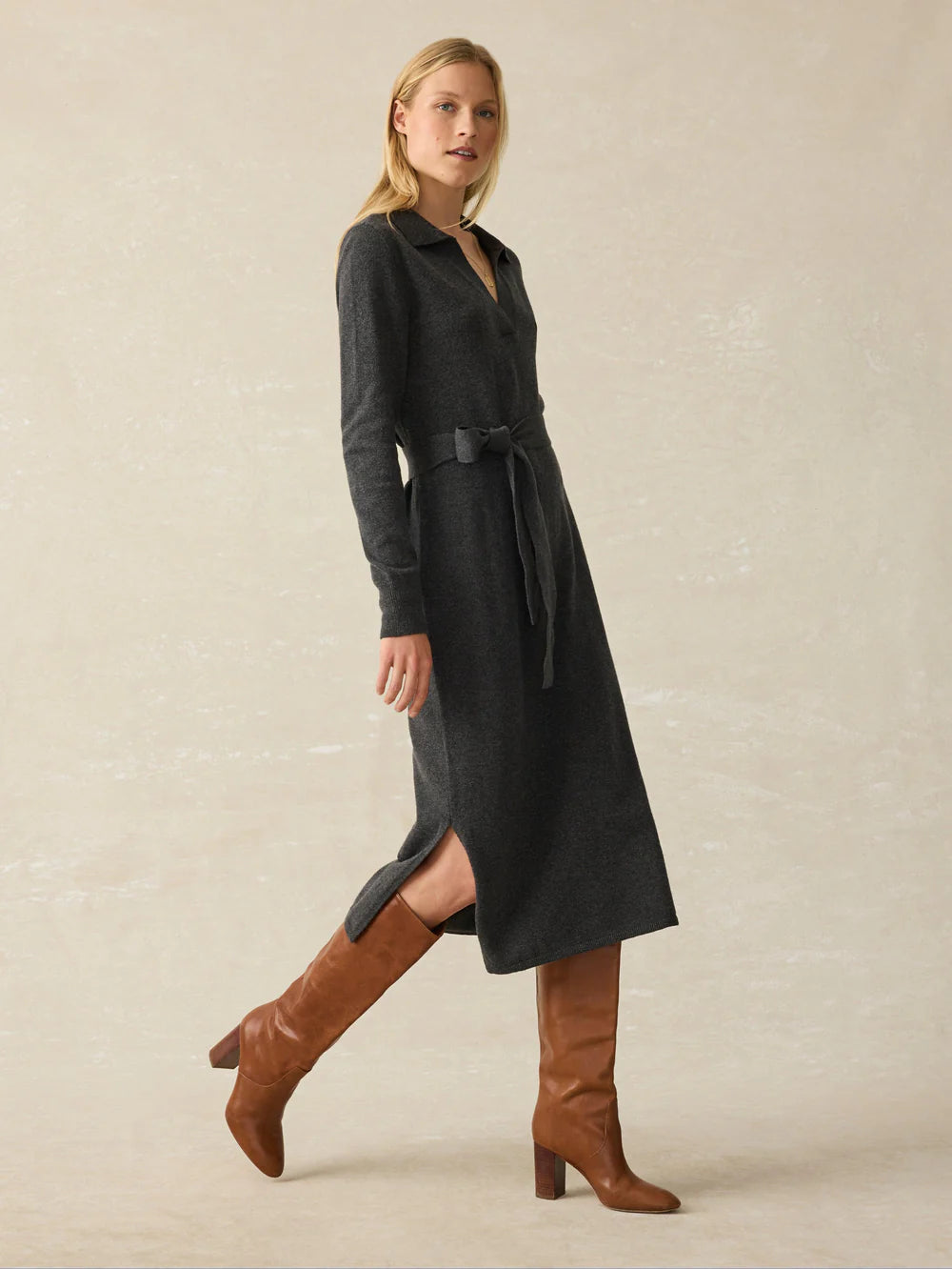 A woman wearing the Medium Grey Heather Jackson Sweater Dress by Faherty, paired with tall brown boots