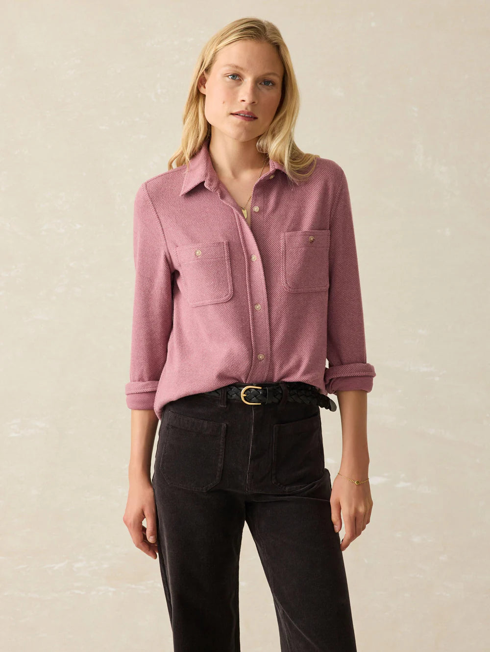 A woman wearing the Rose Twill Legend Sweater Shirt by Faherty tucked into black jeans