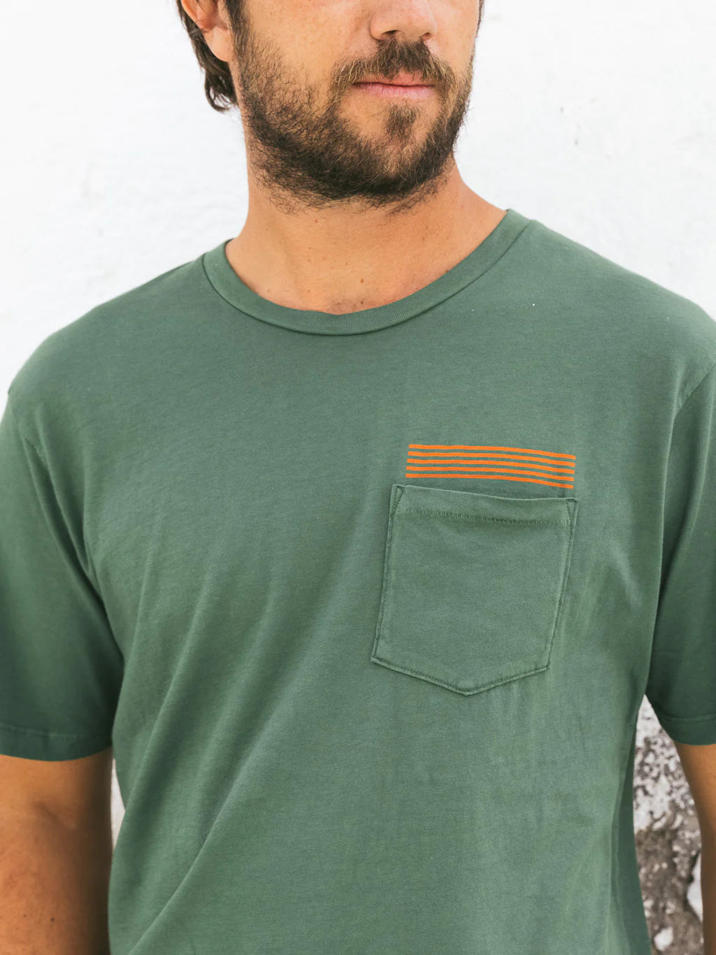 Front view of men's green short sleeve pocket t-shirt with small orange lines above the pocket
