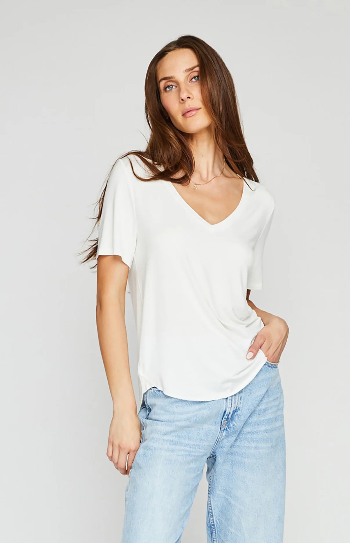 Front view of woman wearing a white, relaxed fit v-neck tee