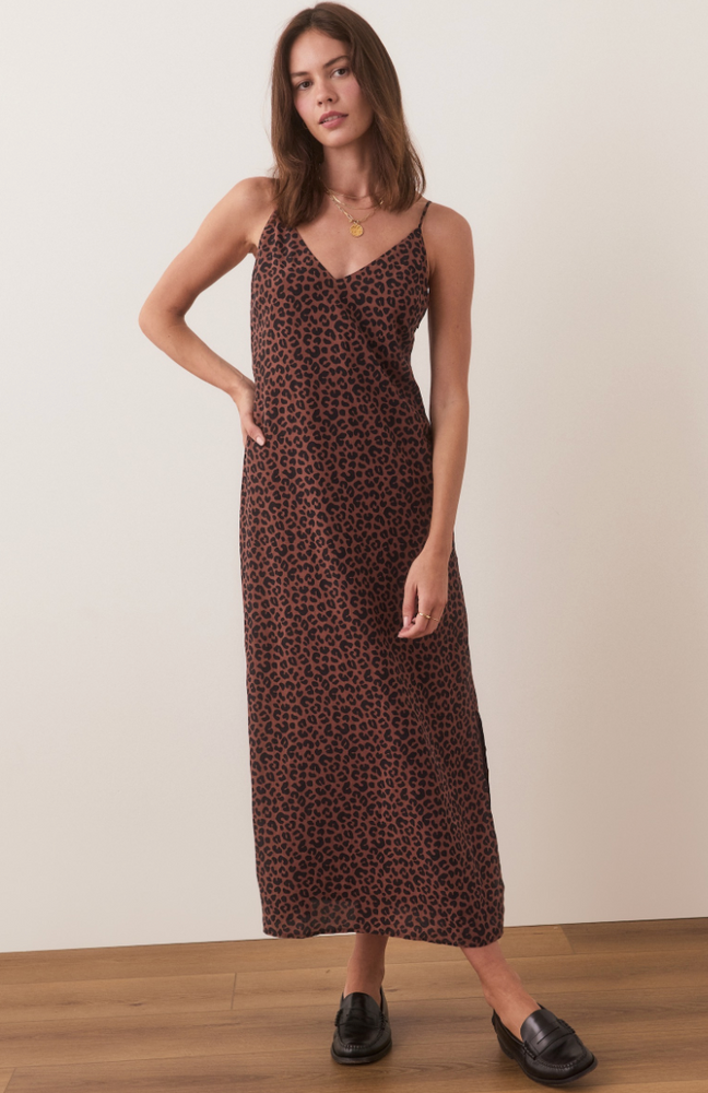 
                      
                        A woman wearing Marine Layer's Gabrielle Slip Dress in Leopard, paired with black loafers
                      
                    