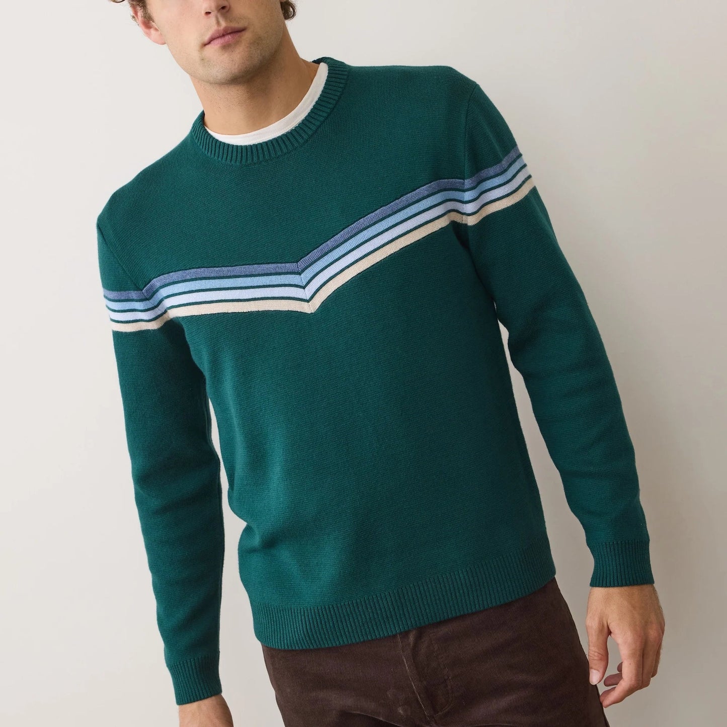 A man wearing the Green Cool Stripe Dean Crew Sweater by Marine Layer