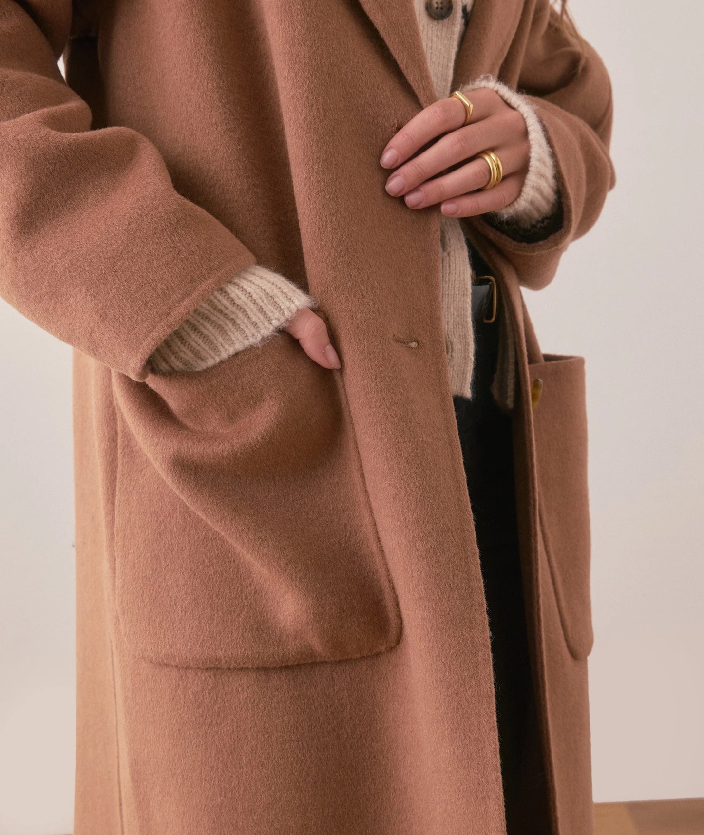 A camel coat with large patch pockets