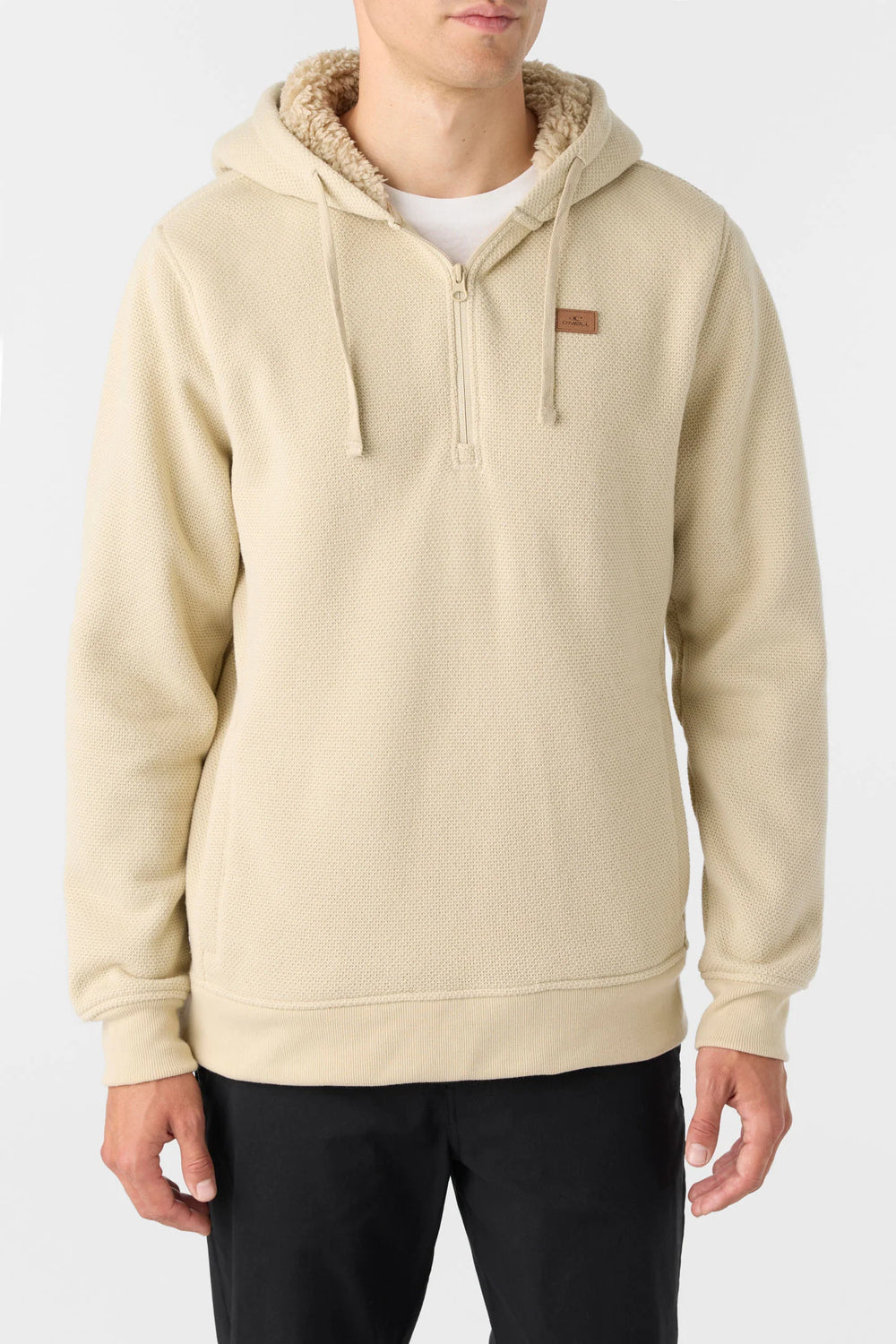 A man wearing the Light Khaki Passage Fleece Quarter Zip Pullover Hoodie by O'Neill