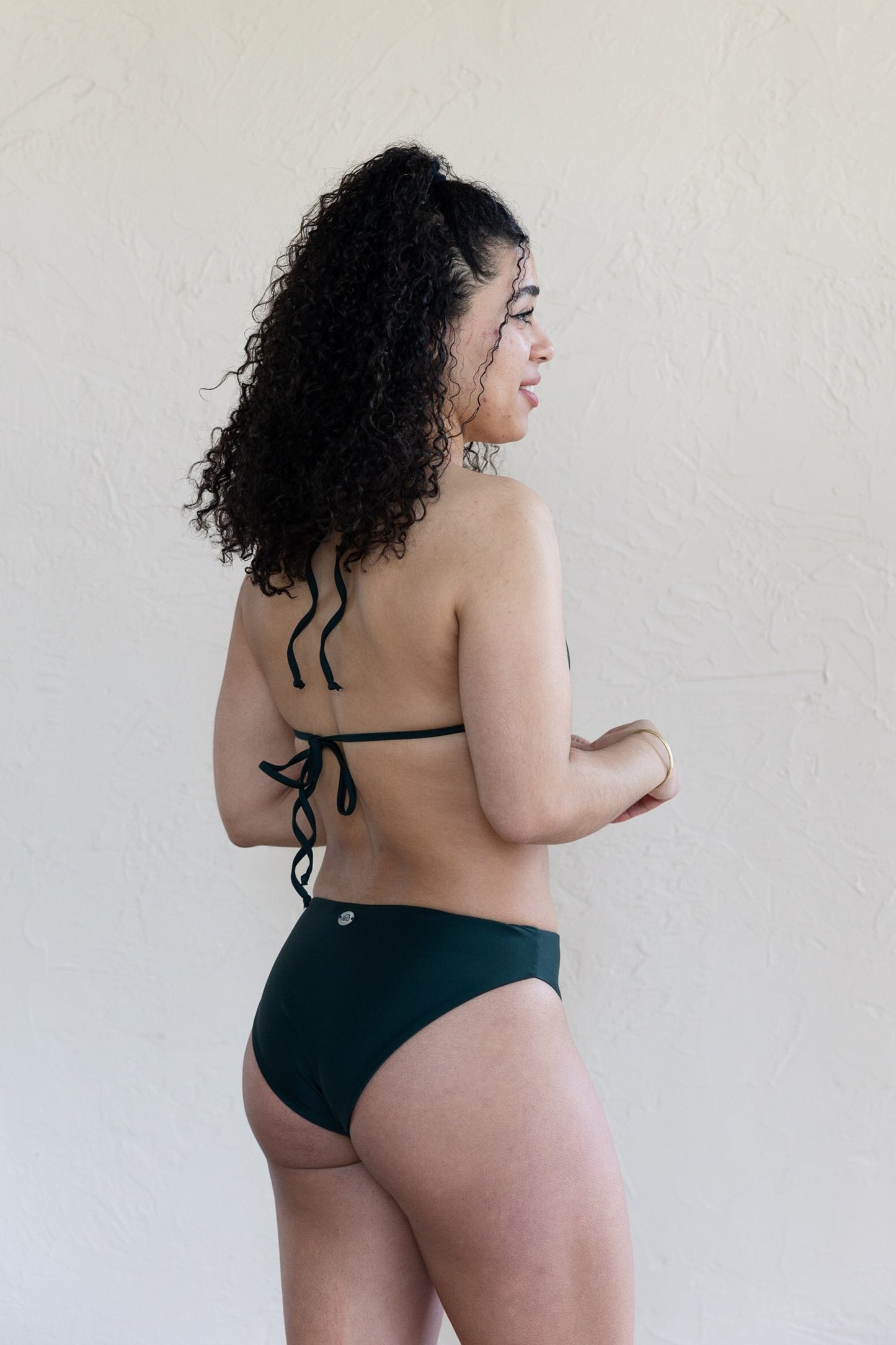 Back view of the dark green luna mid-rise bikini bottoms by Saturday Swimwear