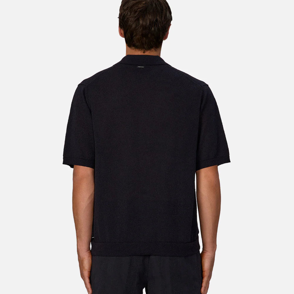 
                      
                        Man wearing a dark navy short sleeve collard shirt
                      
                    