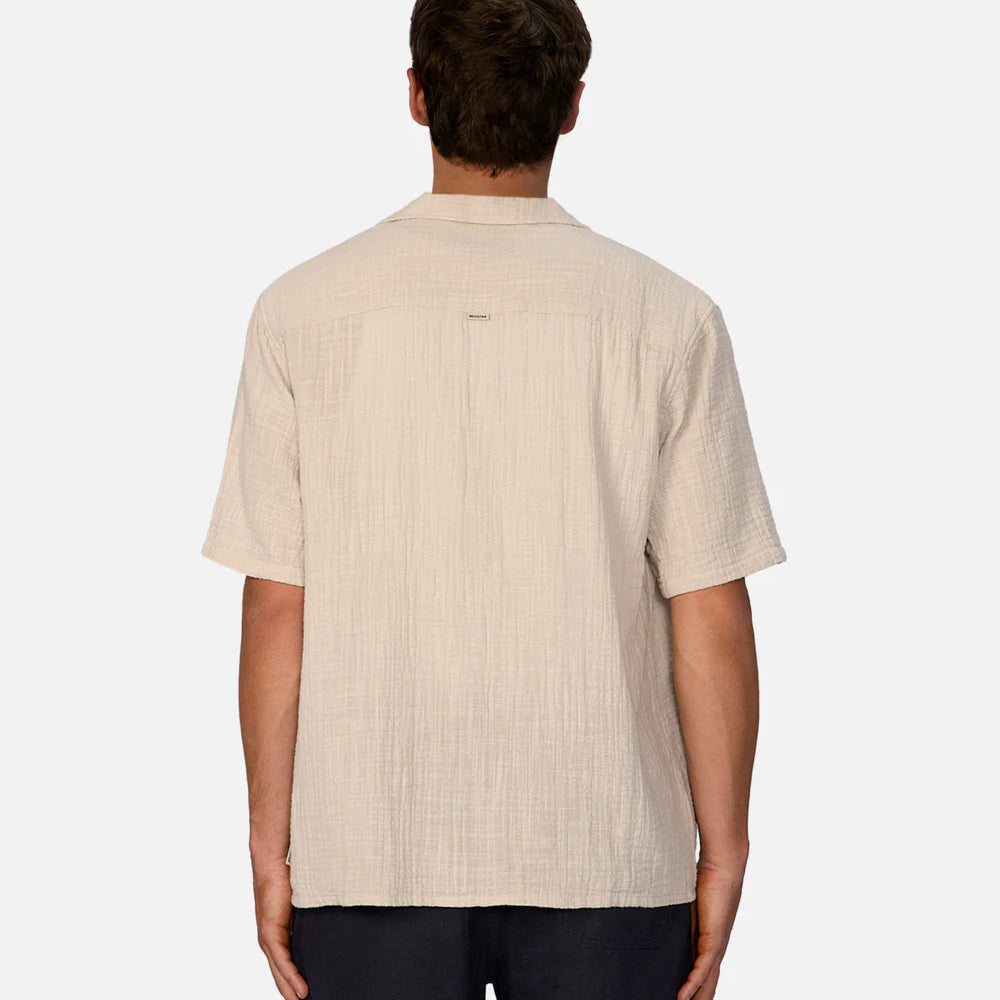 
                      
                        Man wearing a beige short-sleeve shirt on a white background
                      
                    