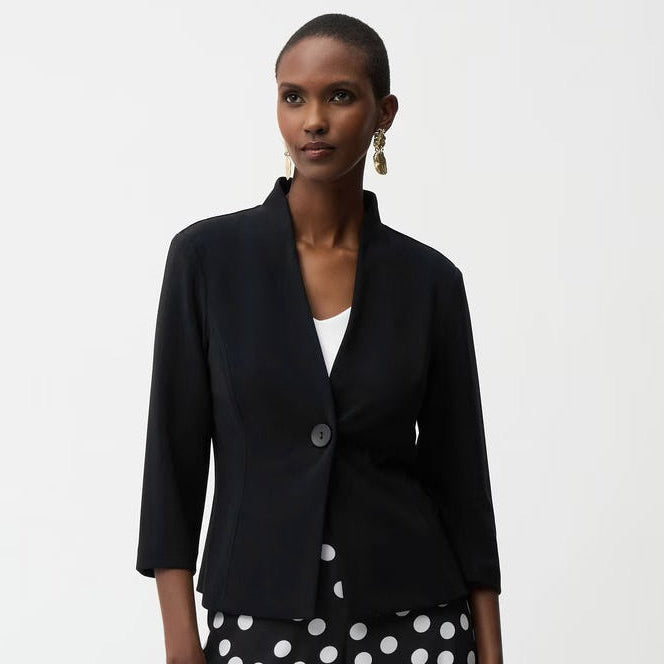 Woman wearing a black blazer and polka dot pants on a white background