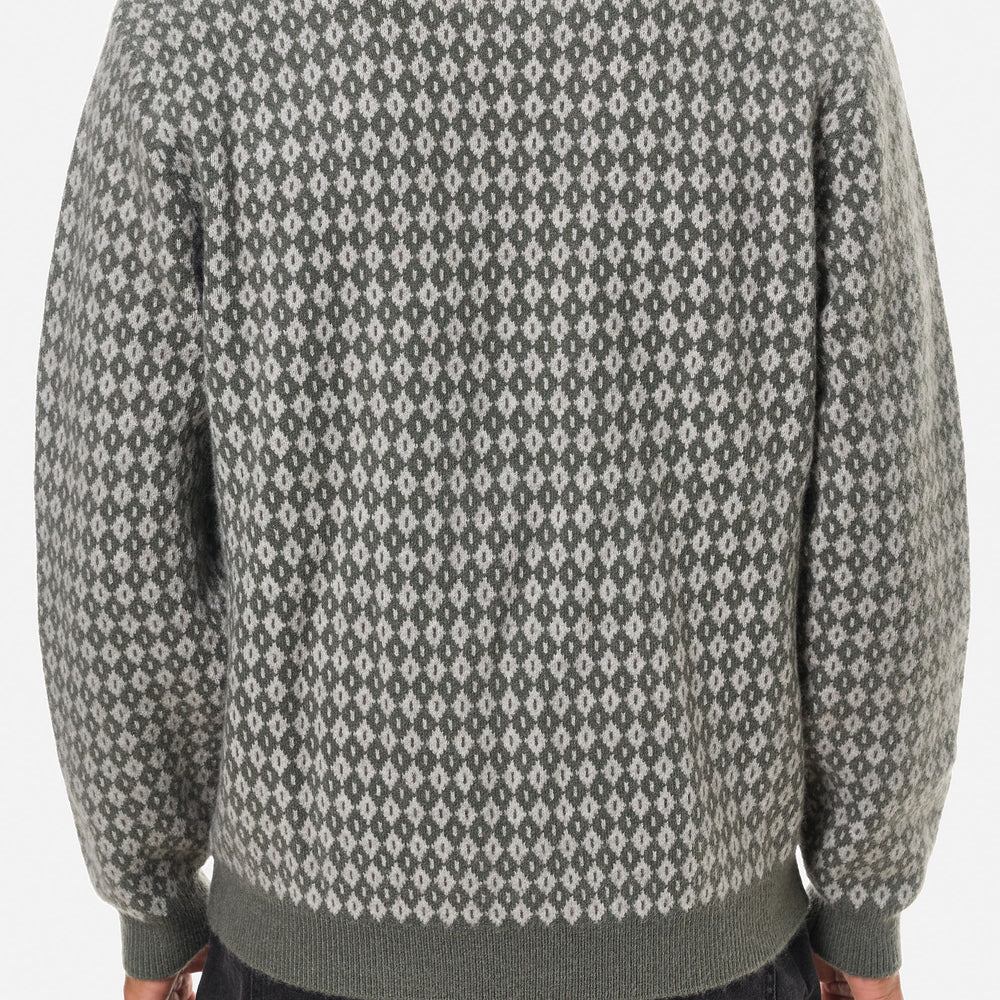 
                      
                        Person wearing a patterned gray sweater on a white background
                      
                    