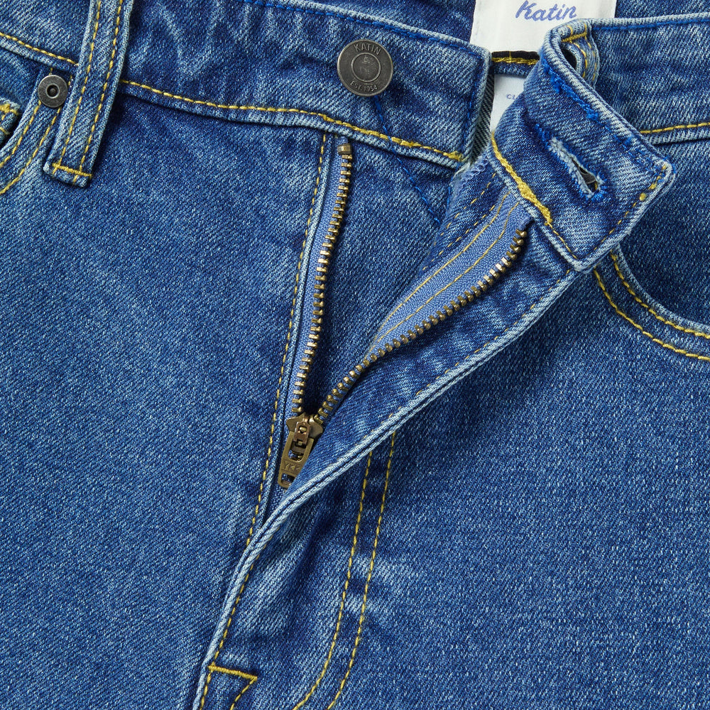 
                      
                        Close-up of blue denim jeans with a Katin label on a white background
                      
                    