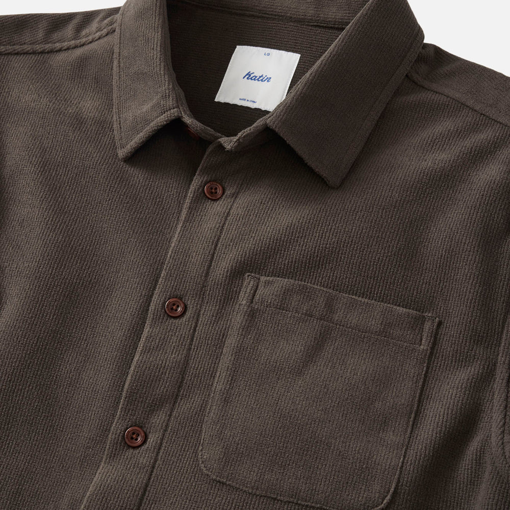 
                      
                        Dark brown corduroy shirt with collar and pocket on a light gray background
                      
                    
