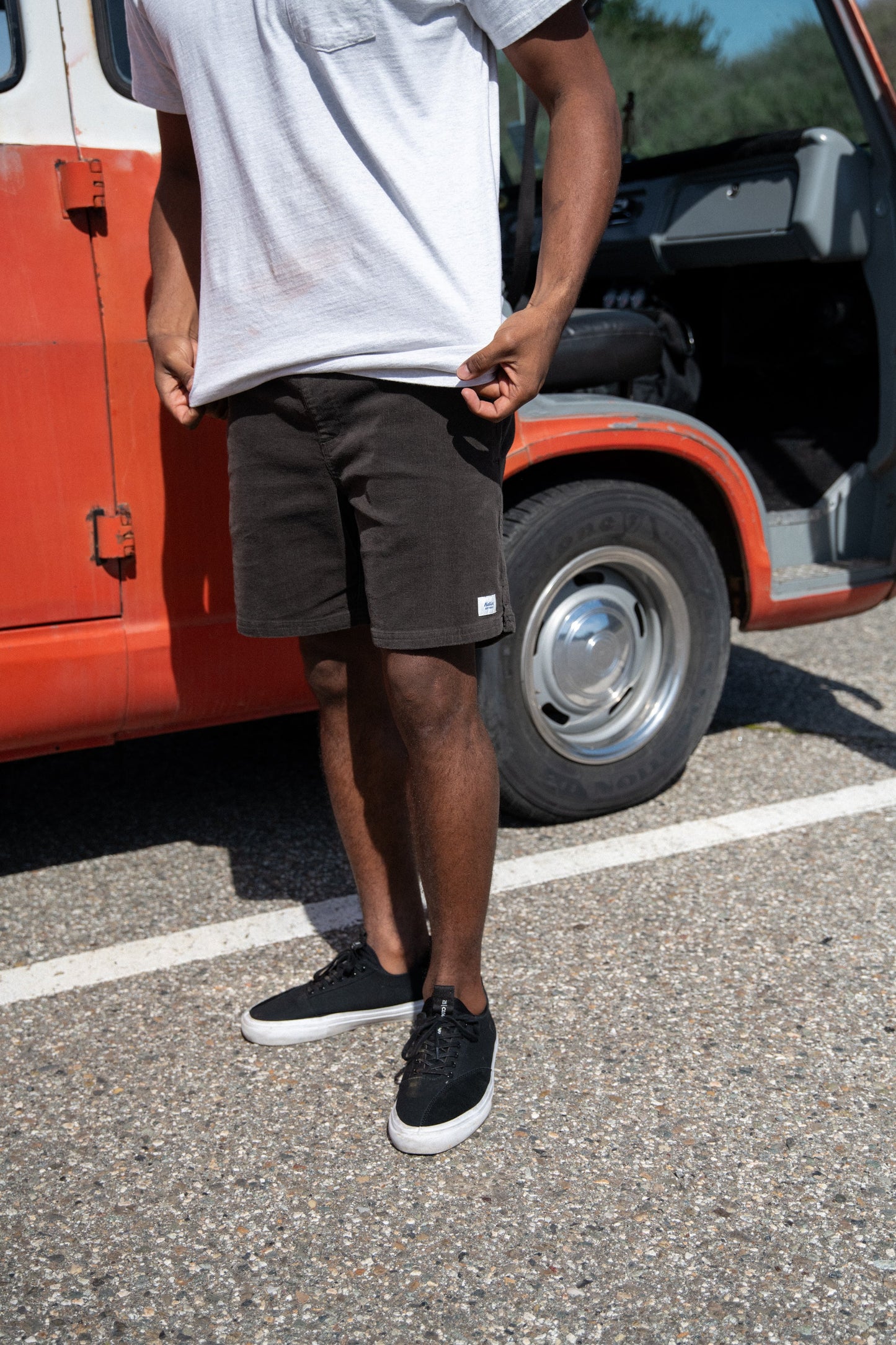 Man outside wearing the Black Wash Cord Local Men's Short by Katin