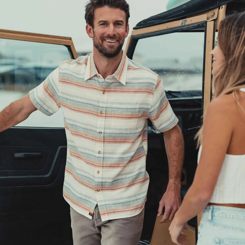 Man wearing The Normal Brand's Freshwater Button Up Shirt in the color Canyon Stripe