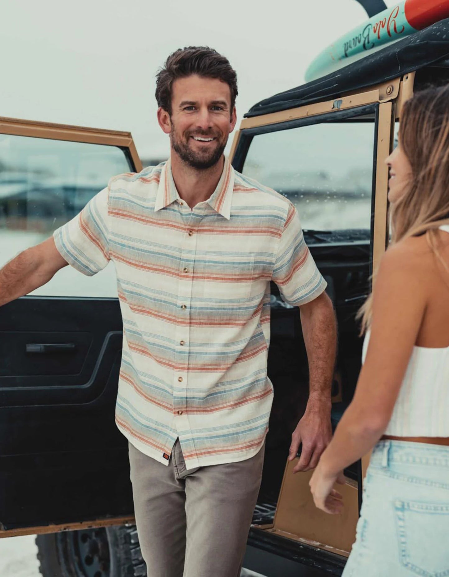 Man wearing The Normal Brand's Freshwater Button Up Shirt in the color Canyon Stripe