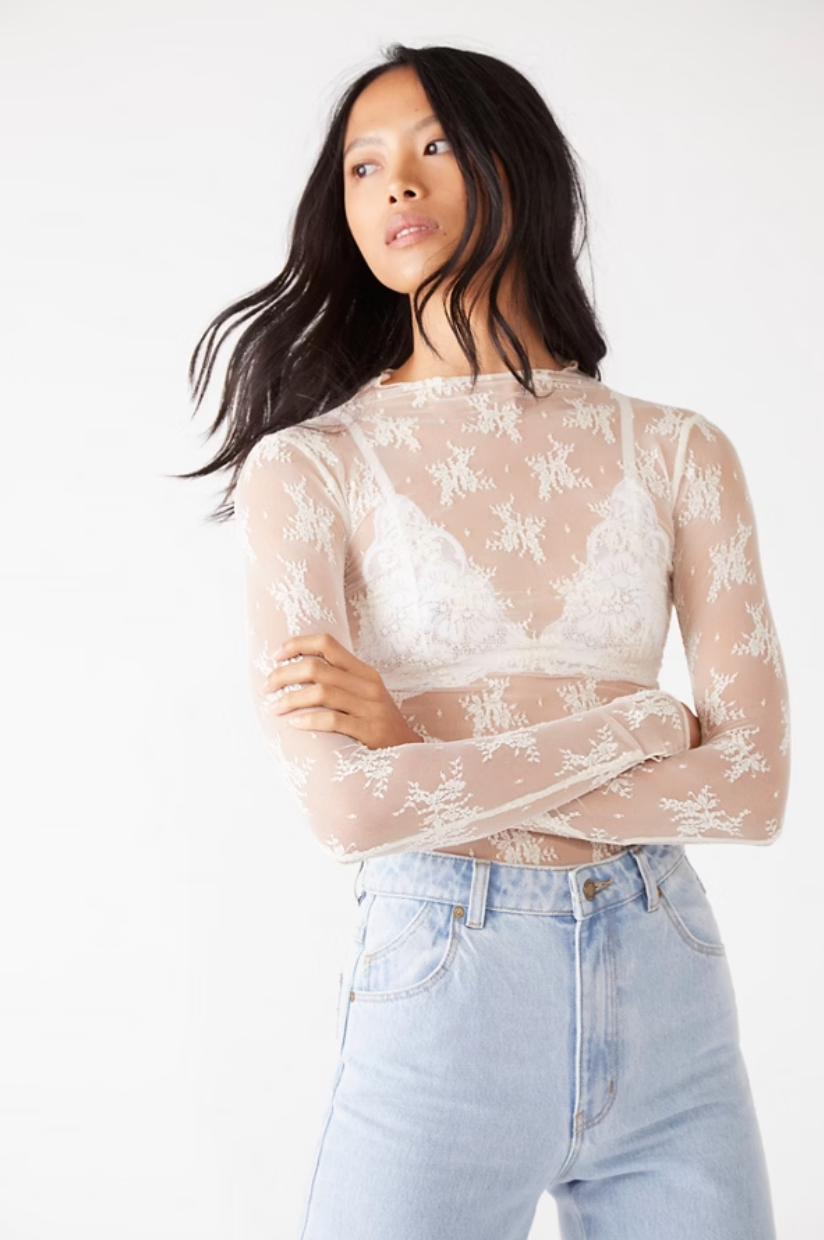 Front view of a woman wearing the Lady Lux Evening Creme Layering Top by Free People