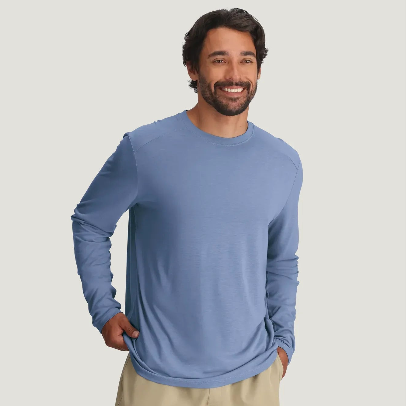 Man wearing a blue long-sleeve shirt and beige shorts from Free Fly