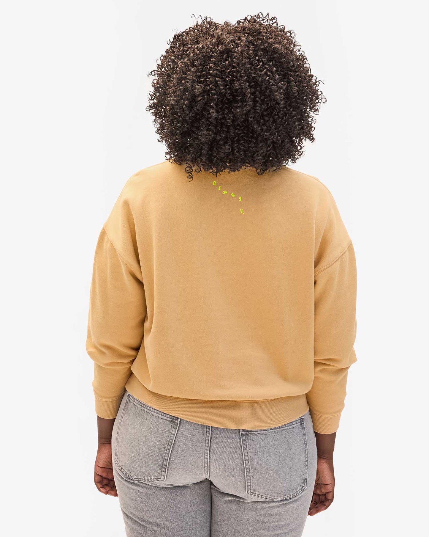 Women's beige crewneck sweatshirt from Clare V. with neon yellow branding on the back. 