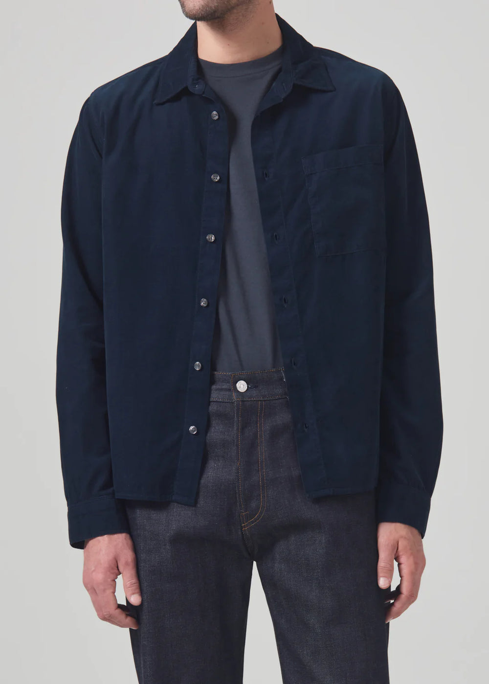 A man wearing the Navy Rework Shirt by Citizens Of Humanity layered over a t-shirt