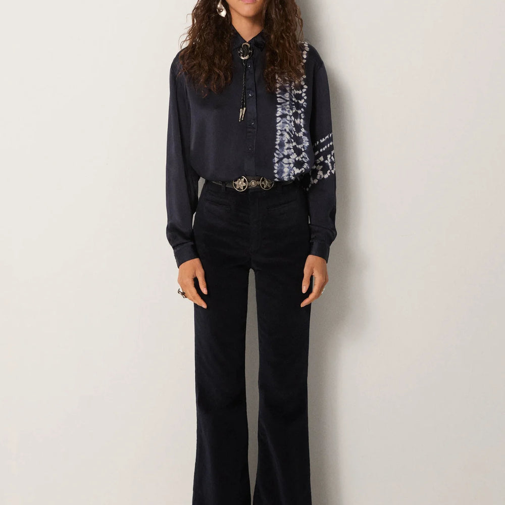 
                      
                        A woman wearing the Maison Hotel Elizabeth Blouse styled with a bolo and slim flare pants
                      
                    