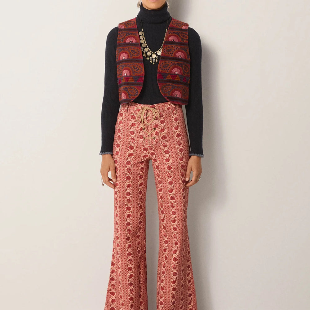 
                      
                        Person wearing a patterned vest, black turtleneck, and pink floral patterned pants 
                      
                    