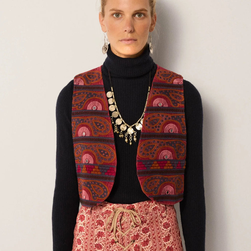 A woman wearing the Gypsy Sun Burgundy Elodie Vest by Maison Hotel layered over a black long sleeve top