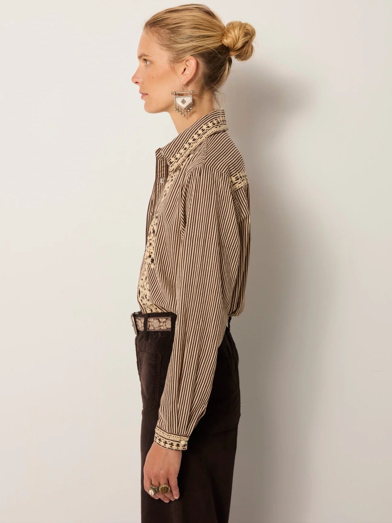 Woman wearing a striped button up shirt with embroidery