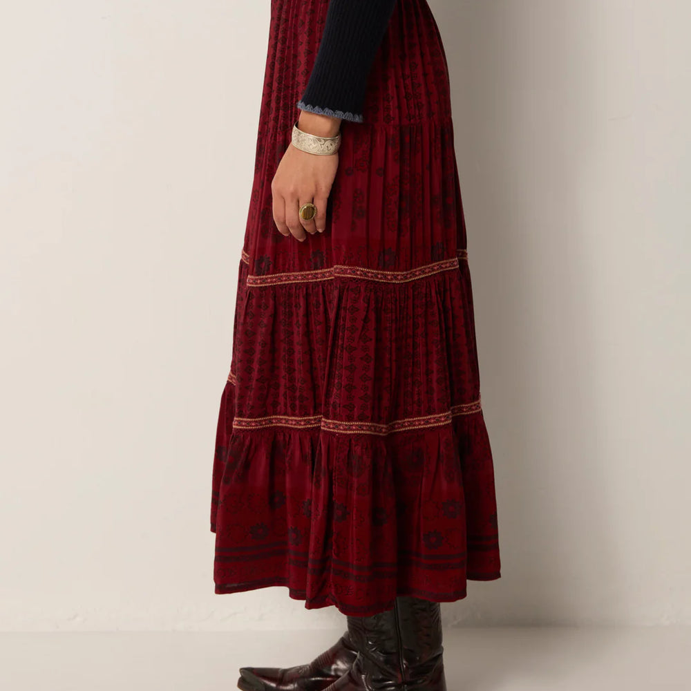 
                      
                        Person wearing a long burgundy skirt with western style boots and a black top
                      
                    