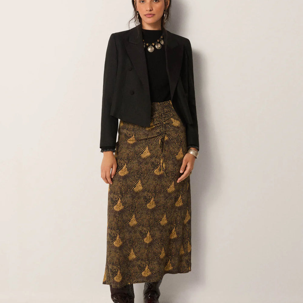 
                      
                        Woman wearing a black blazer, black top, and the Maison Hotel Peacok Avocado Lala Skirt
                      
                    