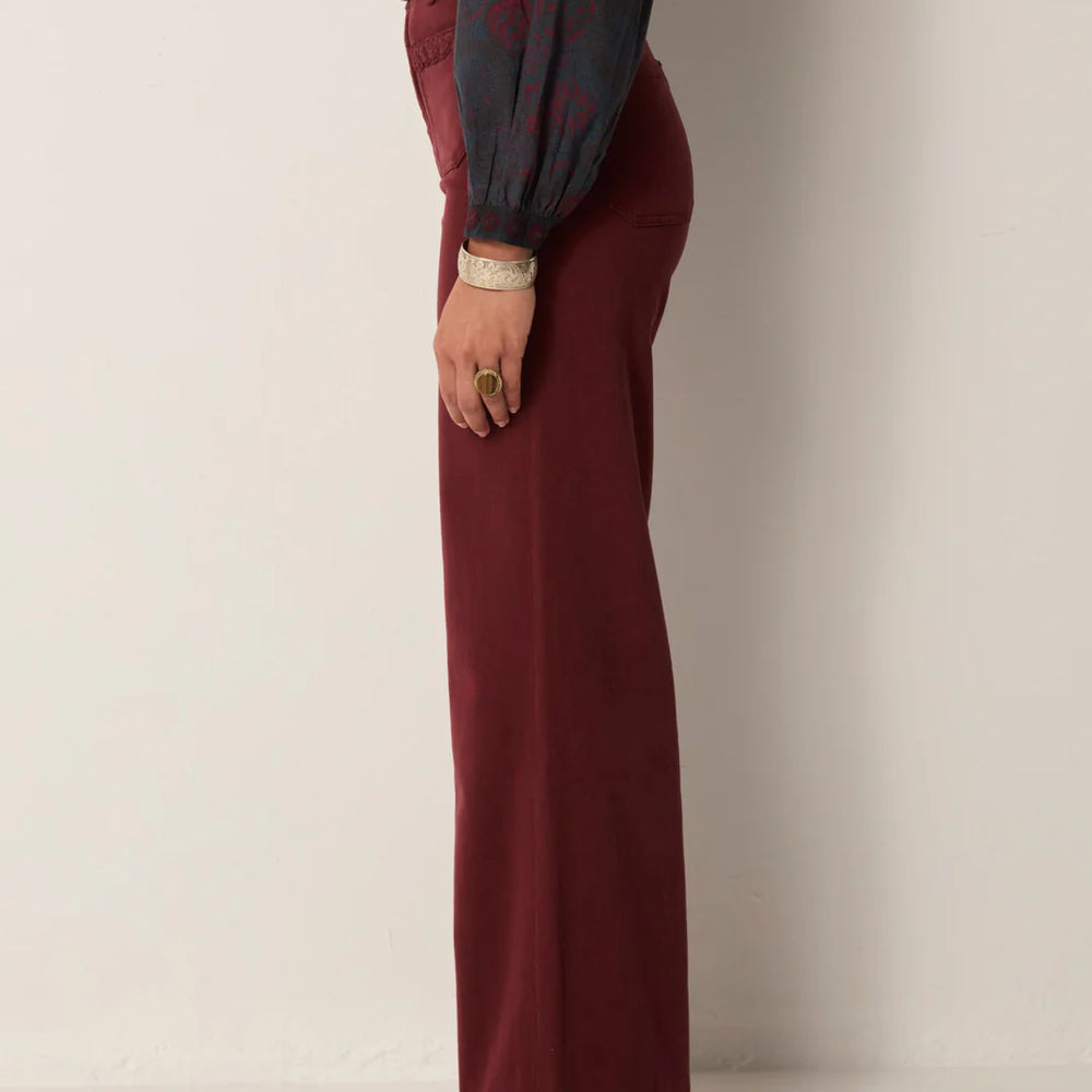 
                      
                        Person wearing burgundy pants and a dark shirt from Maison Hotel
                      
                    
