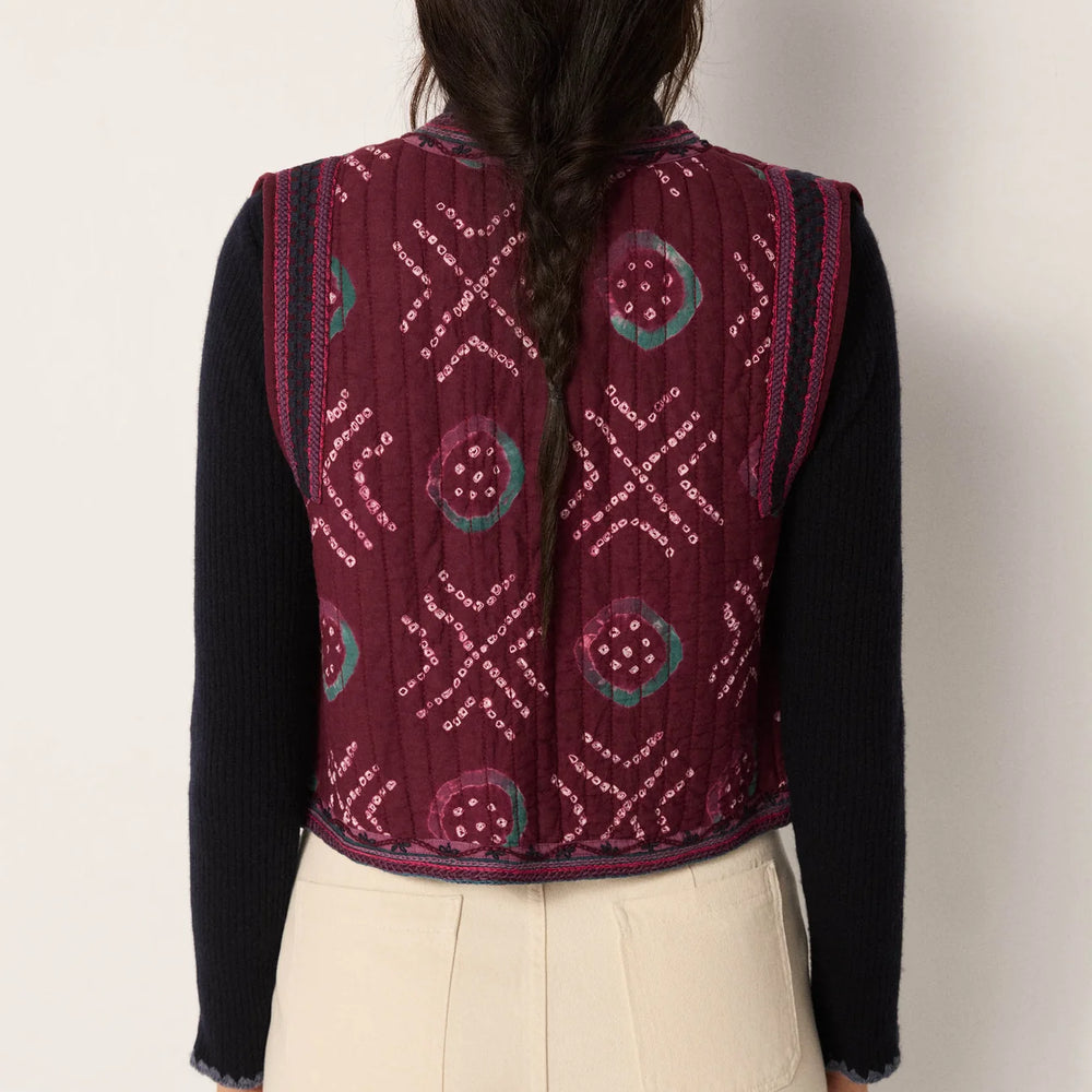 A woman wearing a quilted cotton gauze vest from Maison Hotel with hand-dyed geometric motifs