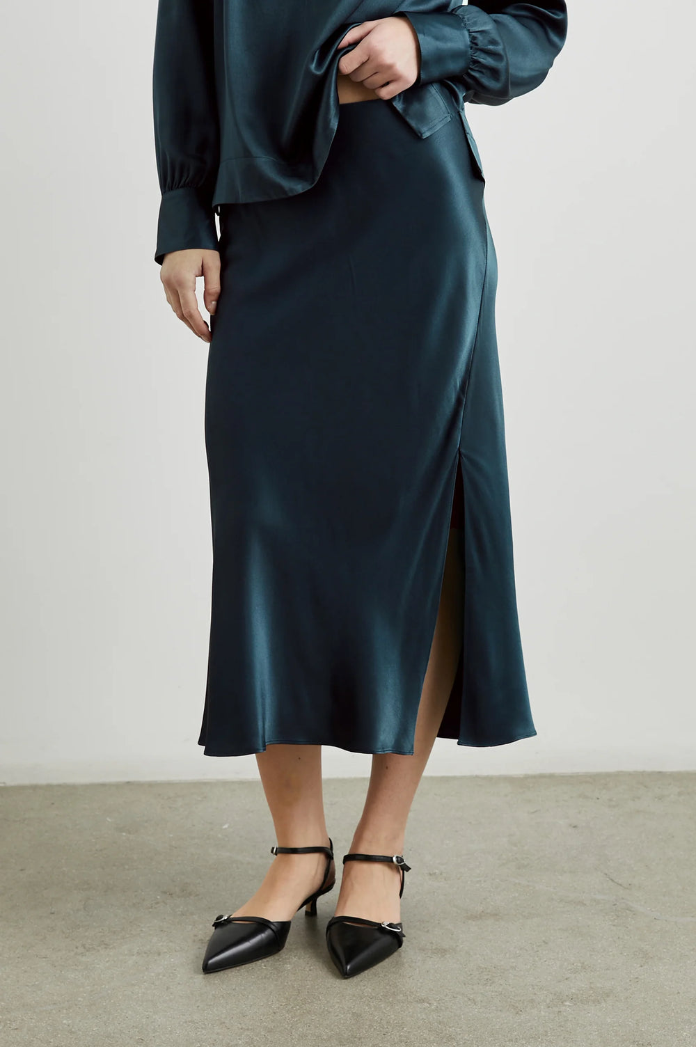 Front view of a woman wearing the Maya Midi Slip Skirt from Rails in the color Deep Sea