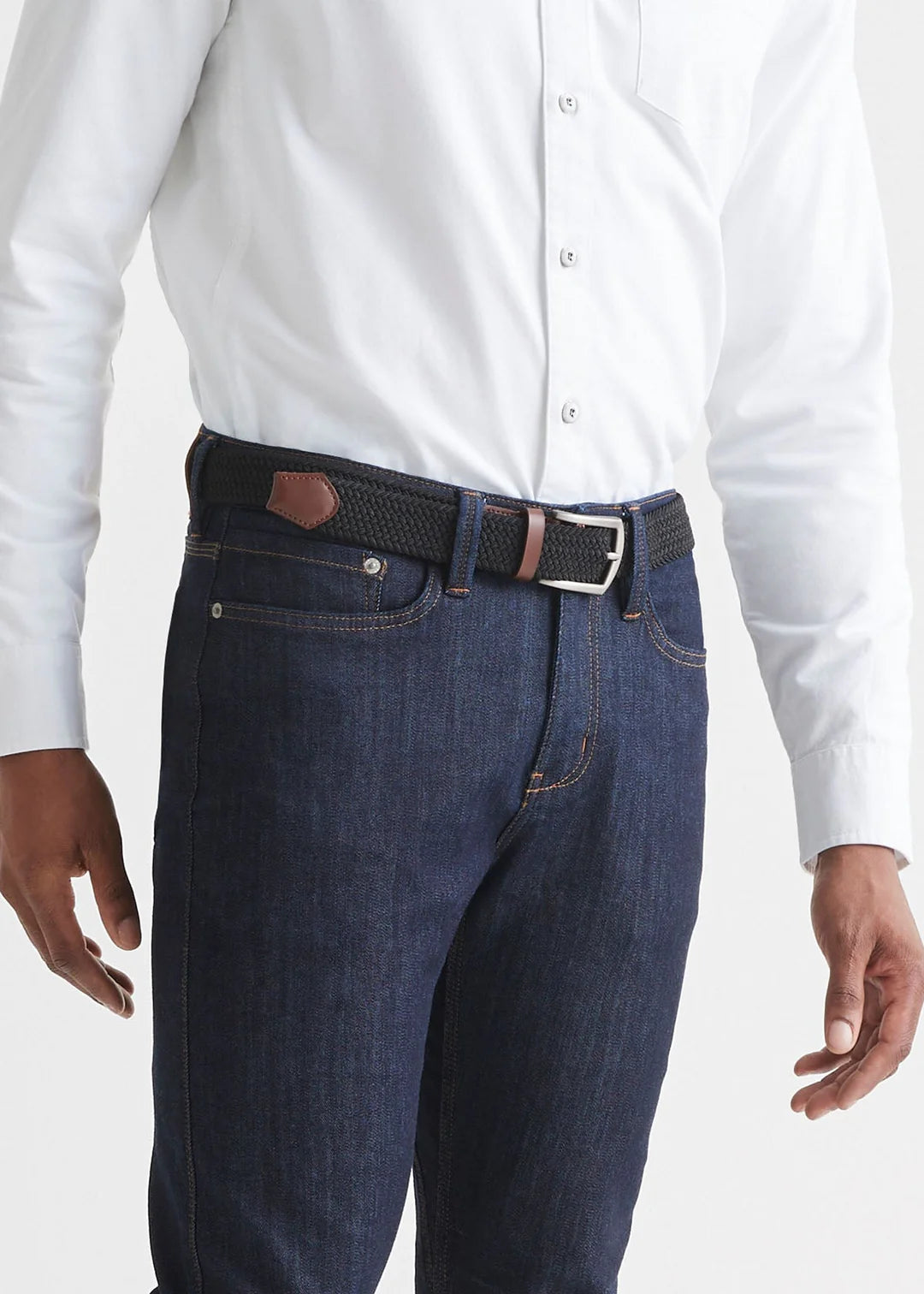 Front view of a man wearing the  Performance Stretch Belt by DU/ER in colors Black/Brown