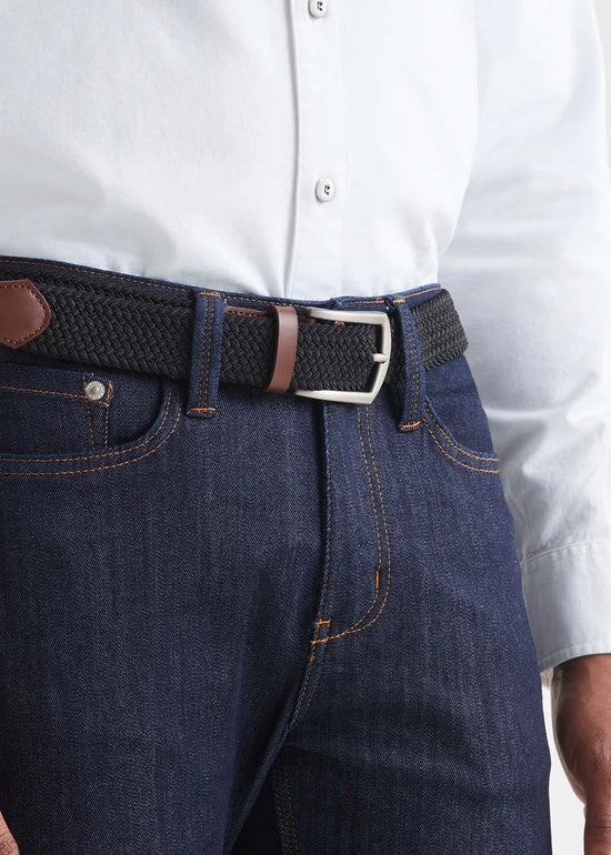 Front view of a man wearing the Performance Stretch Belt by DU/ER in colors Black/Brown