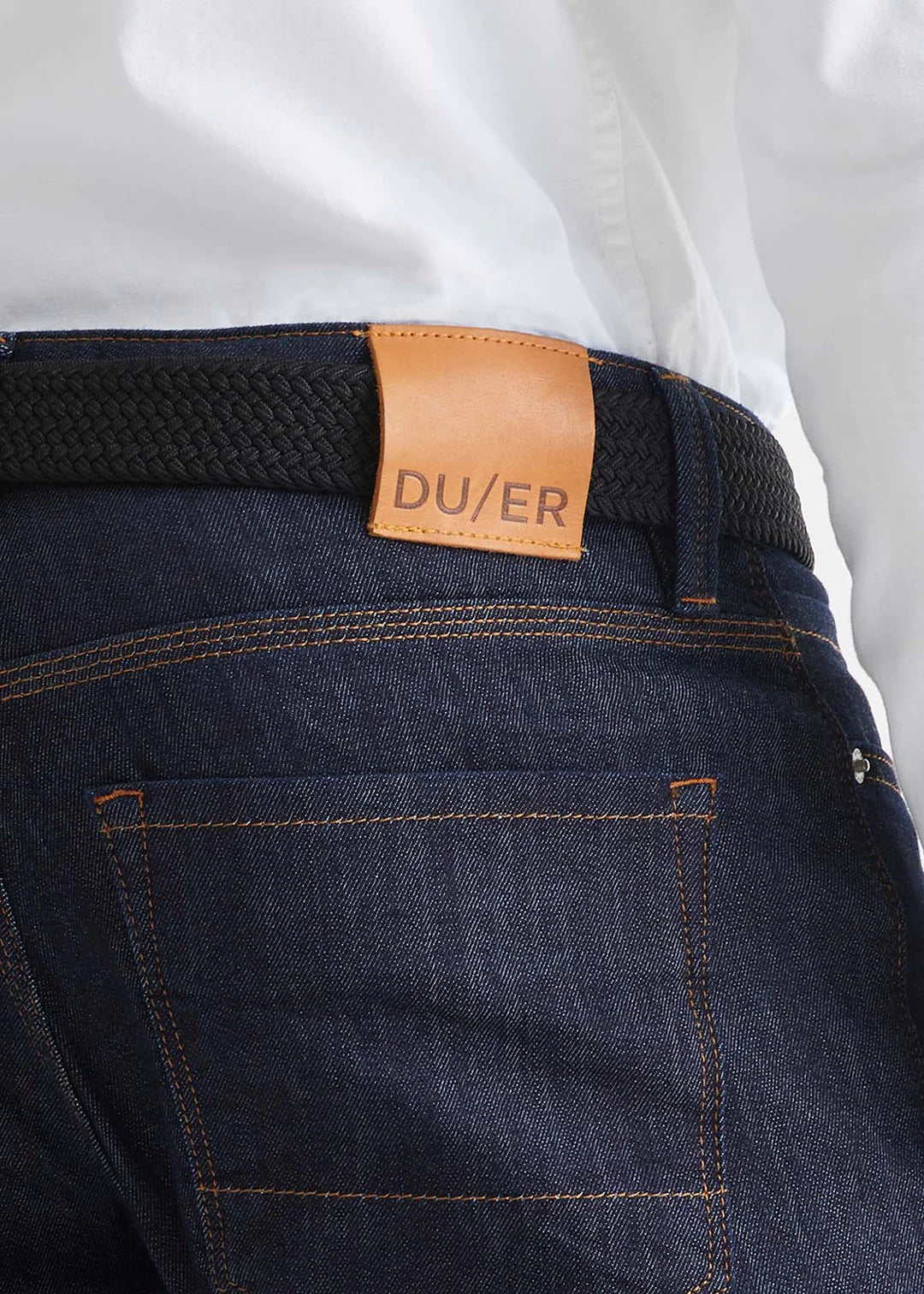 Back view of a man wearing the Performance Stretch Belt by DU/ER in colors Black/Brown