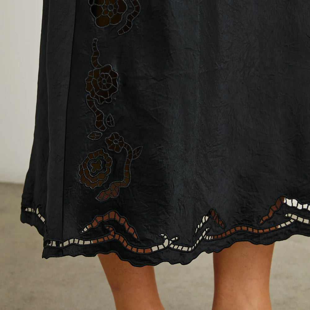 
                      
                        Skirt design detail on the Black Eyelet McKenna Satin Midi Dress by the brand Rails
                      
                    