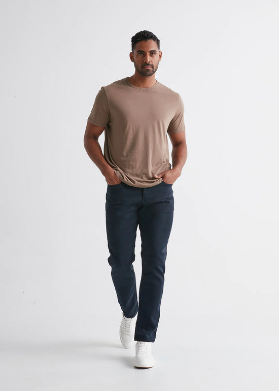 Front view of man wearing the No Sweat Relaxed Taper pant by DUER in color Navy 