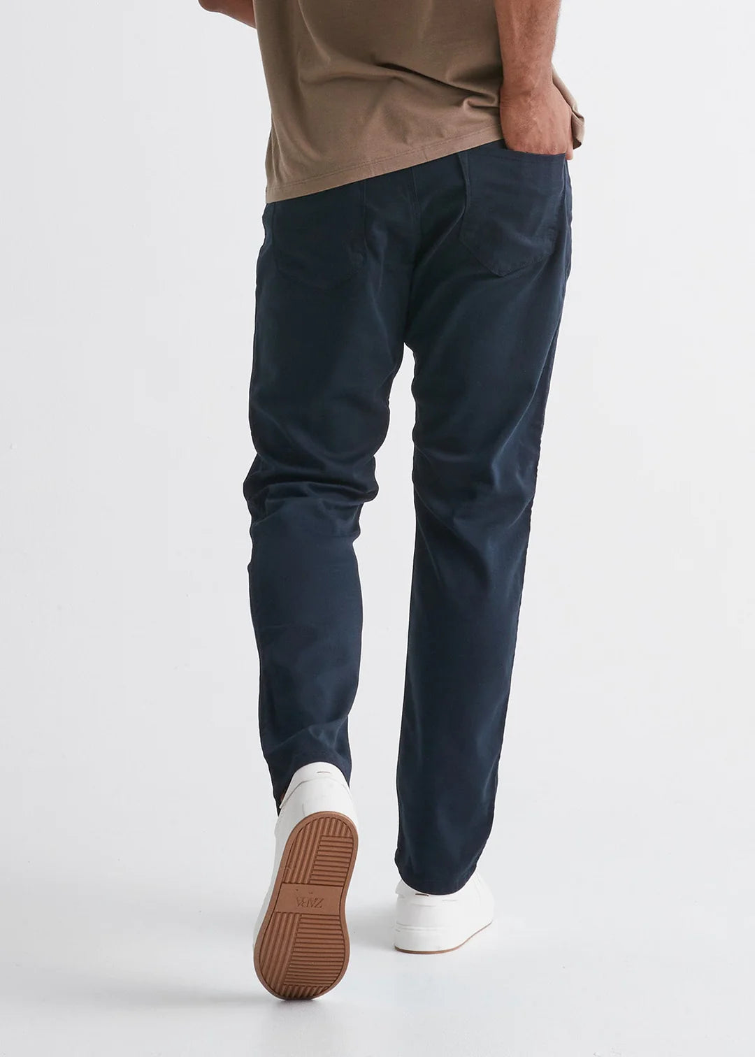 Back view of man wearing the No Sweat Relaxed Taper pant by DUER in color Navy