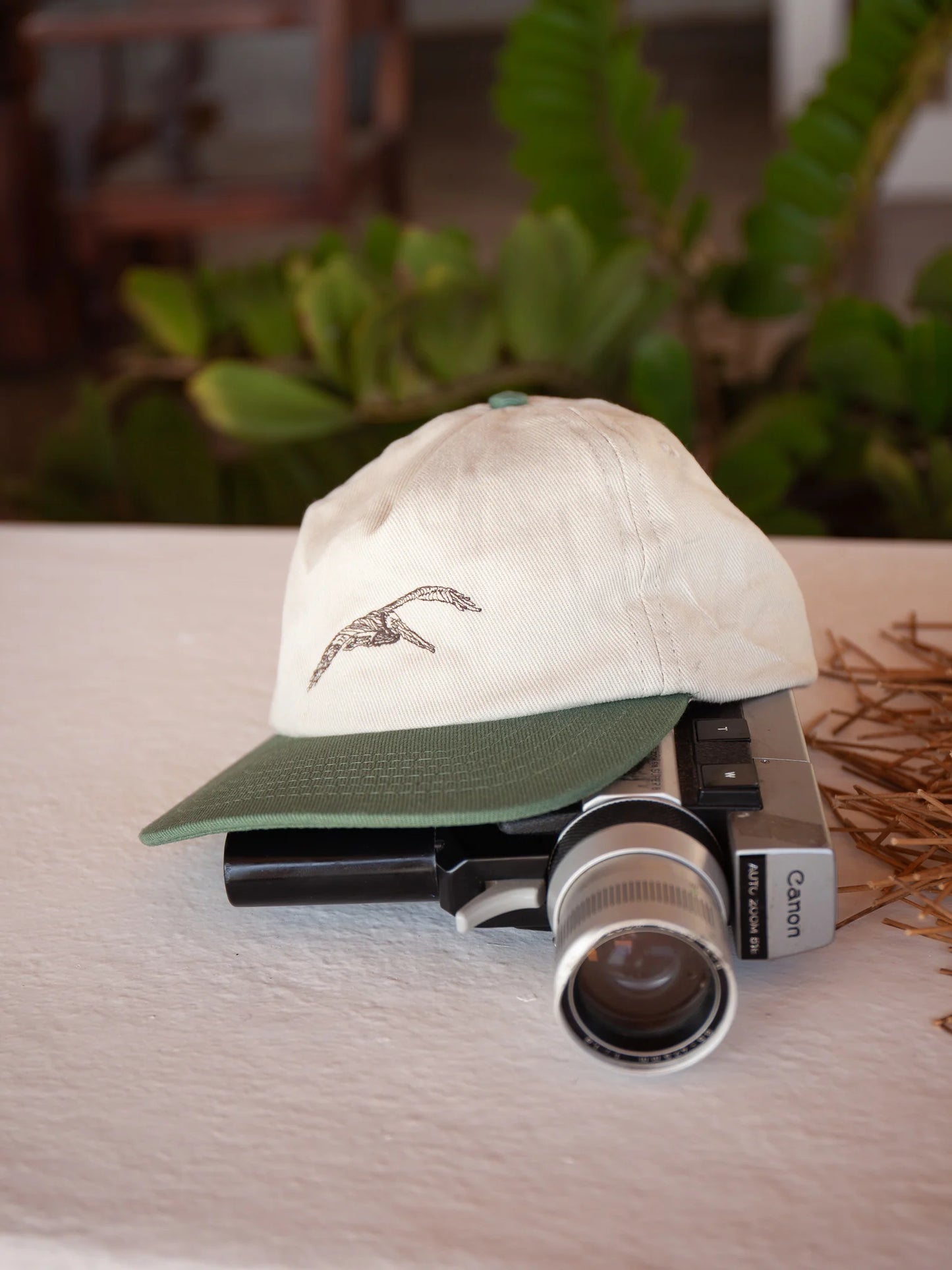 front view of the khaki color Flite Hat by Mollusk, featuring a green bill and pelican graphic on the front