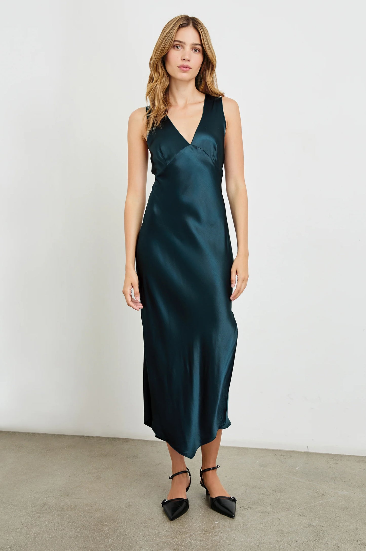 A woman wearing the Monique Midi Slip Dress in the color Deep Sea by the brand Rails