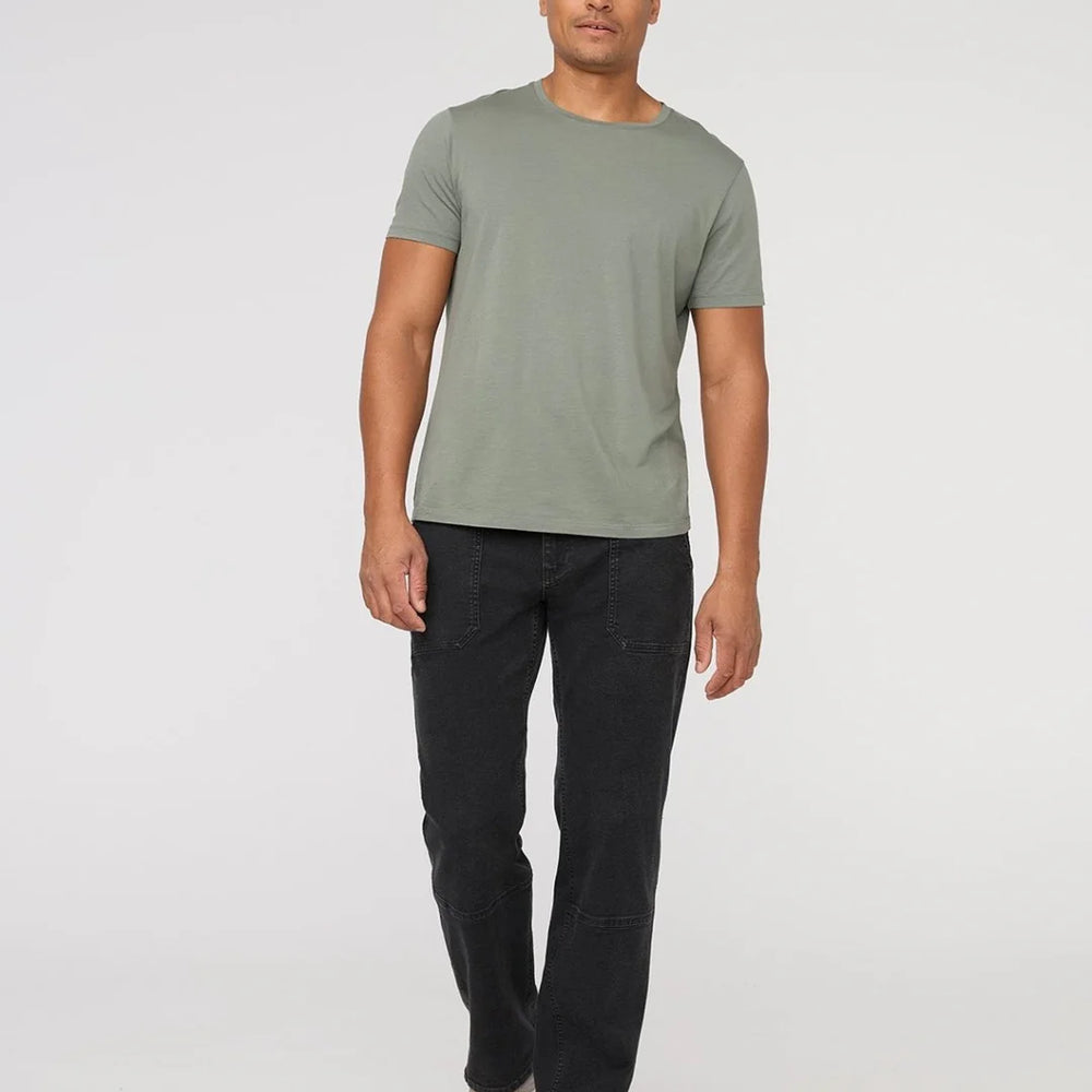 A man wearing the DUER Men's Black Stretch Canvas Utility Pant