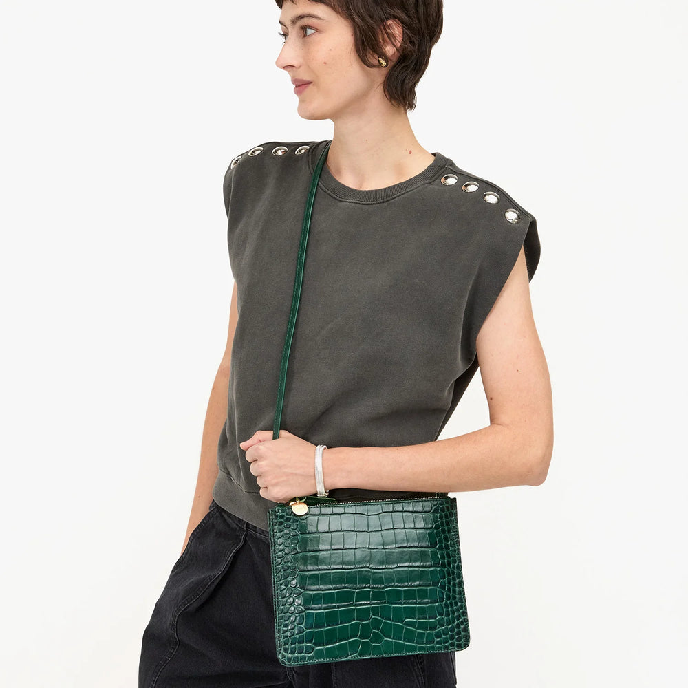 
                      
                        Woman holding a green crocodile-patterned handbag from Clare V.
                      
                    