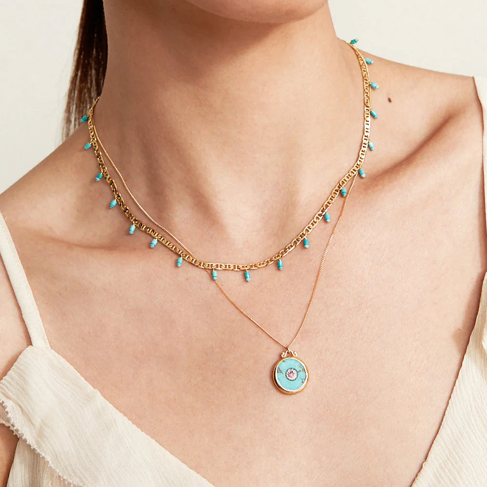 
                      
                        Woman wearing the Turquoise Celeste Necklace by Chan Luu layered with another necklace
                      
                    