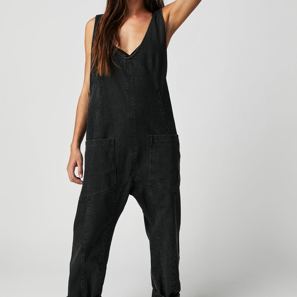 Front view of a woman wearing the Mineral Black High Roller Jumpsuit by Free People