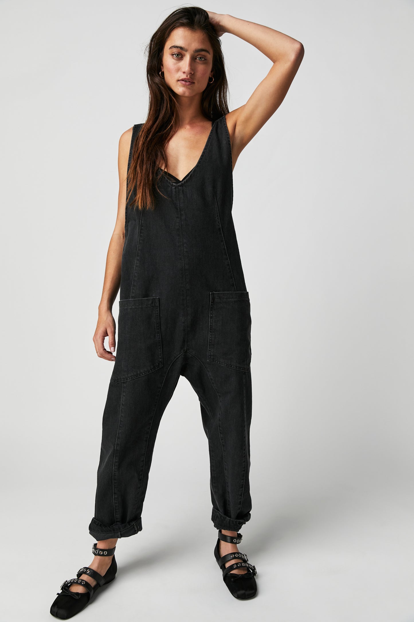 Front view of a woman wearing the Mineral Black High Roller Jumpsuit by Free People