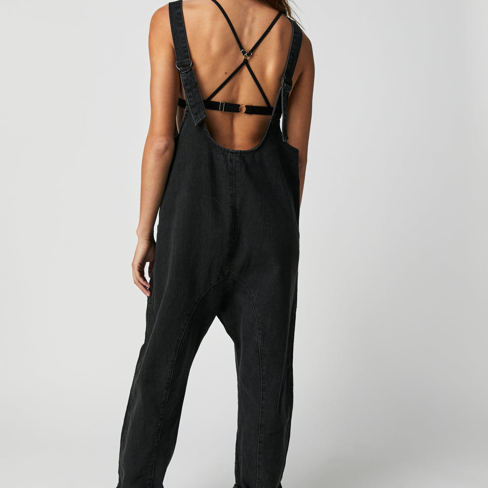 Back view of a woman wearing the Mineral Black High Roller Jumpsuit by Free People