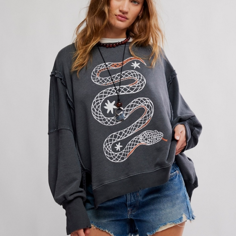 Woman wearing a dark gray sweatshirt from Free People with a snake design